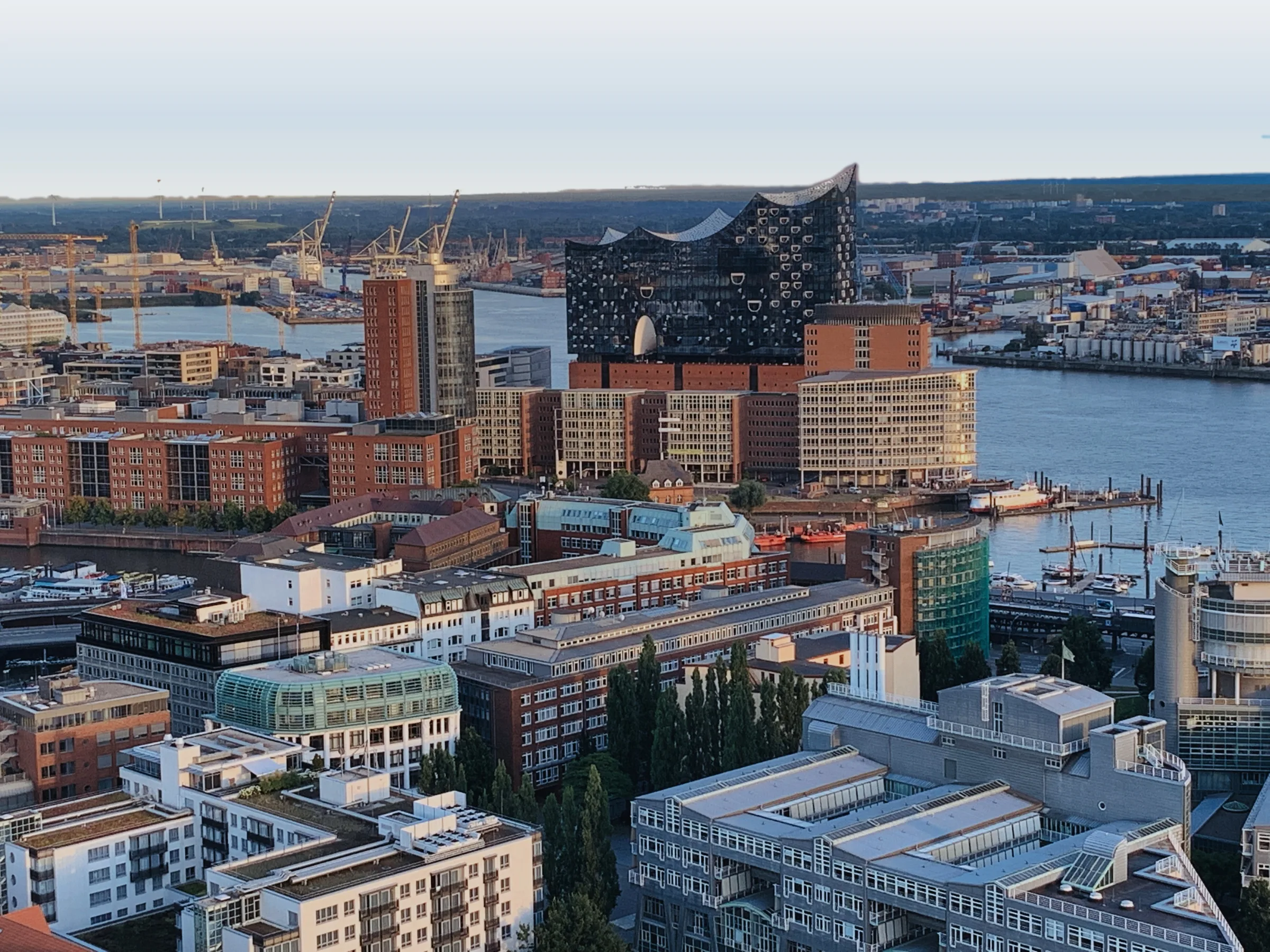 Hamburg von oben: HafenCity und Elbphilharmonie an der Elbe, dahinter der Hafen im Morgenlicht